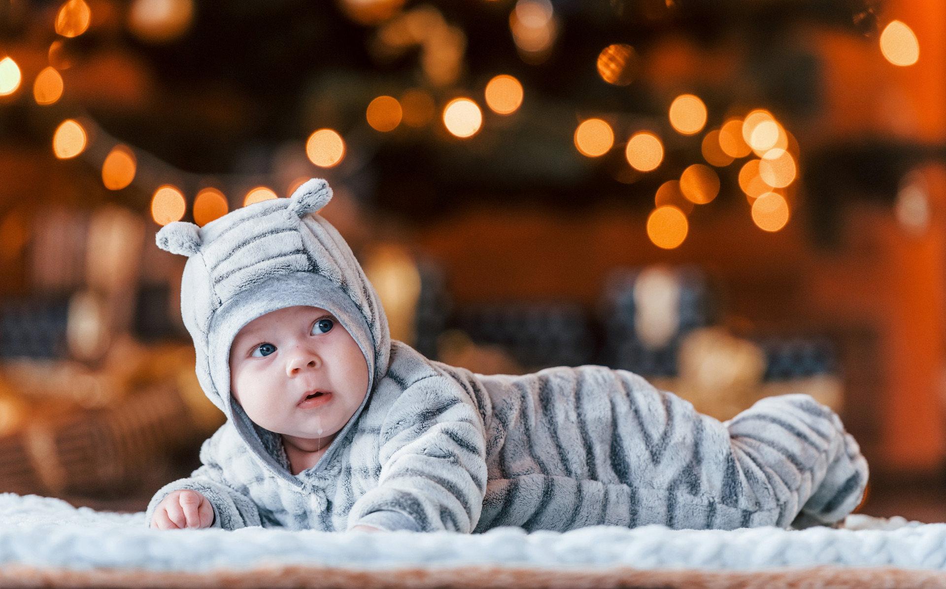 Cute little baby lying down in the christmas decorated room.